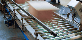 Packages roll down a conveyor system in a warehouse